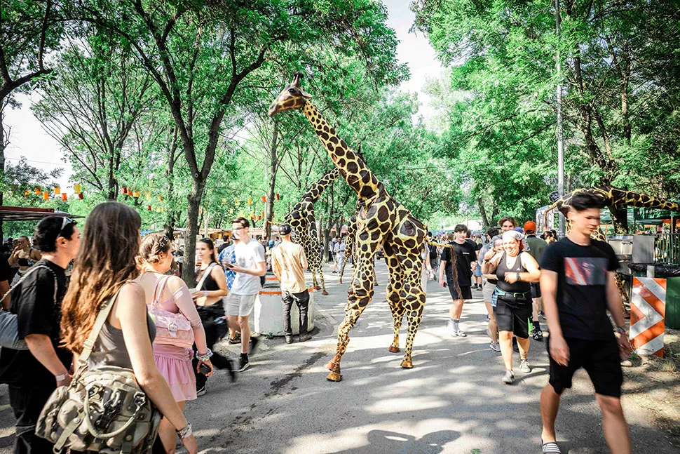 Künstler als Walking-Act als Giraffe verkleidet auf dem Sziget Festival